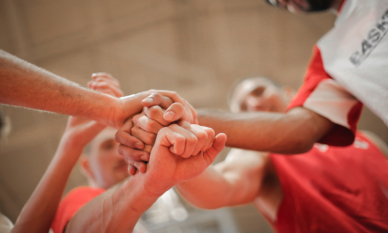 team stacking hands together